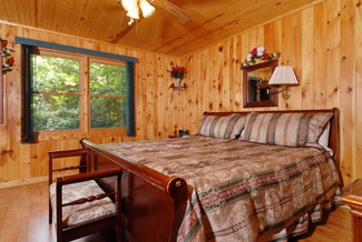 Cabin with wood from floor to ceiling and a large bed
